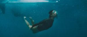 woman diving and doing breathing techniques underwater